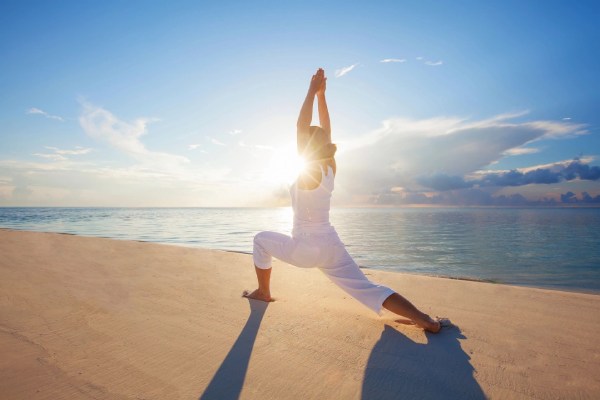 Girl doing yoga on the beach