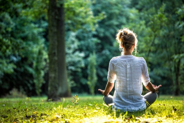 Woman doing mediation in the pleasant greenery